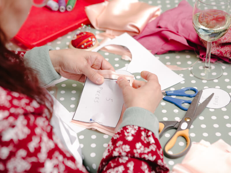 Hands working with a sewing pattern and pins